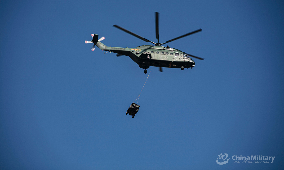A helicopter attached to a brigade with the army under the PLA Southern Theater Command conducts sling load operation with an assault vehicle during a training exercise in mid-September, 2022. Photo:China Military