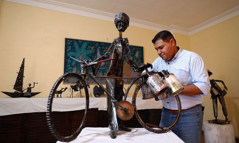 Egyptian sculptor Ammar Shiha cleans one of his artworks made of scrap metal at his home in Giza, Egypt, on Sept. 3, 2022.(Photo: Xinhua)