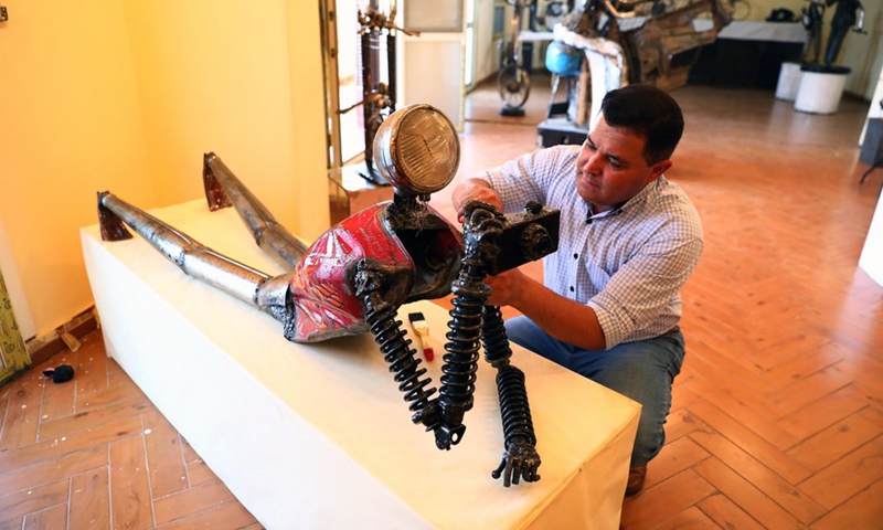 Egyptian sculptor Ammar Shiha is seen with one of his artworks made of scrap metal at his home in Giza, Egypt, on Sept. 3, 2022.(Photo: Xinhua)