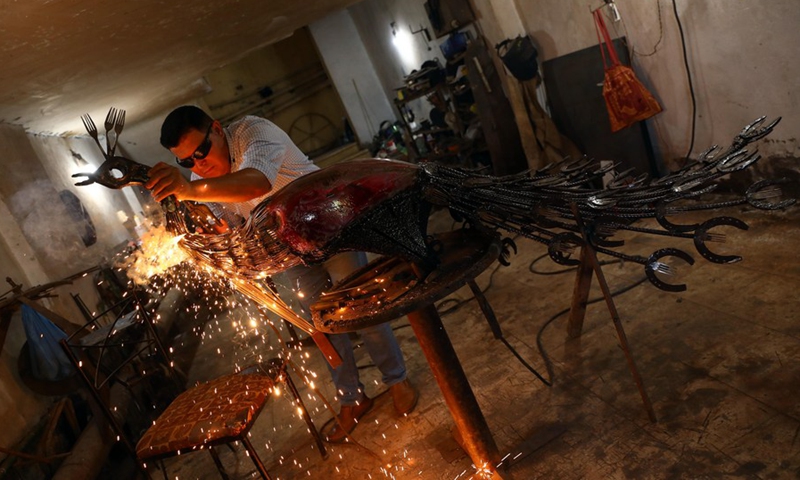 Egyptian sculptor Ammar Shiha makes an artwork with scrap metal at his home in Giza, Egypt, on Sept. 3, 2022.(Photo: Xinhua)