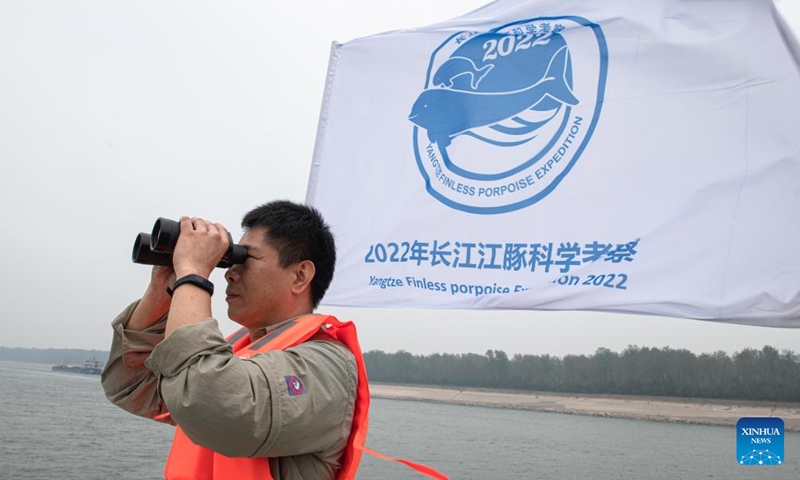 A researcher uses a pair of binoculars to conduct monitoring work during a scientific expedition on Yangtze finless porpoises at the Shishou section of the Yangtze River, central China's Hubei Province, Sept. 23, 2022.Photo:xinhua