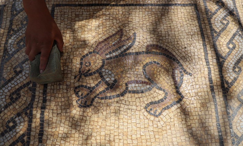 A man cleans parts of a Byzantine-era mosaic at Buraij refugee camp in the middle of the Gaza Strip, Sept. 21, 2022.Photo:Xinhua
