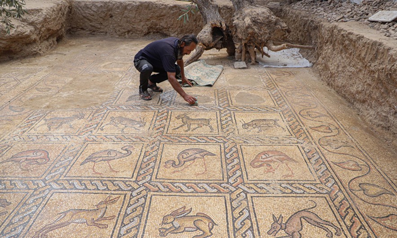 A man cleans parts of a Byzantine-era mosaic at Buraij refugee camp in the middle of the Gaza Strip, Sept. 21, 2022.Photo:Xinhua