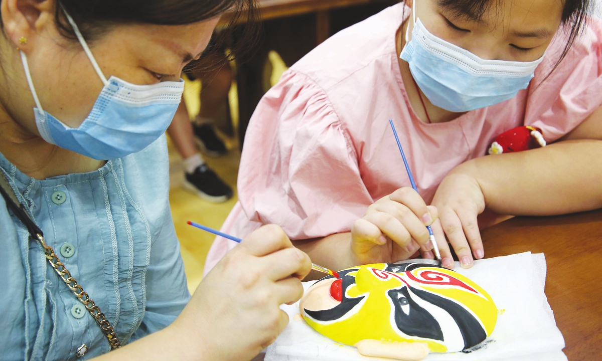 Children in Lianyungang, Jiangsu Province, learn how to draw a Peking Opera mask. Photo: IC