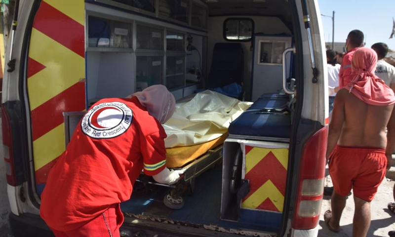 A Syrian Red Crescent worker helps move the bodies of victims of a migrant boat which sank off the Syrian shore last Thursday in the city of Tartous, Syria, Sept. 25, 2022.Photo:Xinhua