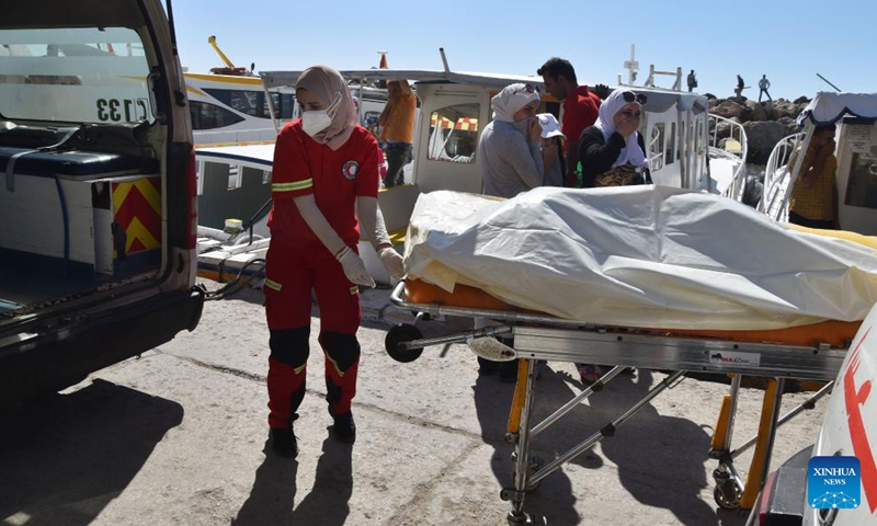 A Syrian Red Crescent worker helps move the bodies of victims of a migrant boat which sank off the Syrian shore last Thursday in the city of Tartous, Syria, Sept. 25, 2022.Photo:Xinhua