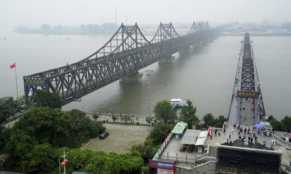 Visitors walk across the Yalu River Broken Bridge, (right), next to the Friendship Bridge connecting China and North Korea in Dandong in Liaoning Province, September. 9, 2017. Photo: VCG