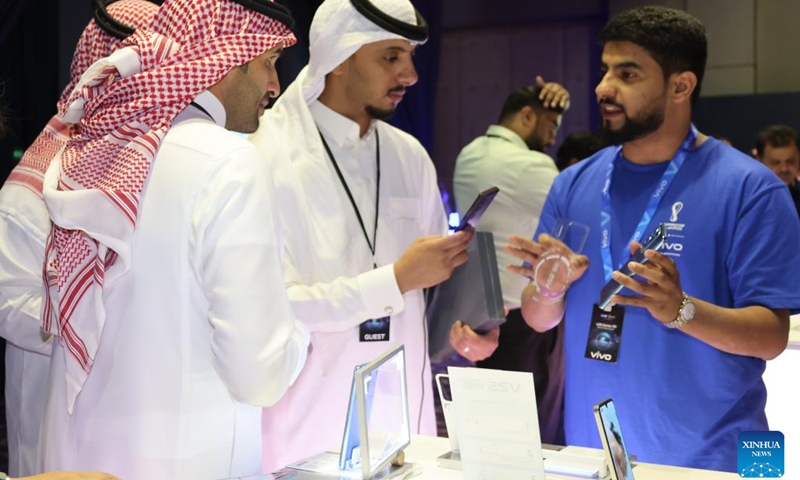 A staff member introduces a new smartphone to visitors during a launch of Vivo's new products in Riyadh, Saudi Arabia, on Sept. 26, 2022. Chinese phone maker Vivo unveiled on Monday two 5G smartphones in Riyadh. At its launch of new products in the kingdom, Vivo presented the latest additions to its 5G smartphones V series: V25 and V25 Pro, which feature superior photography.(Photo: Xinhua)