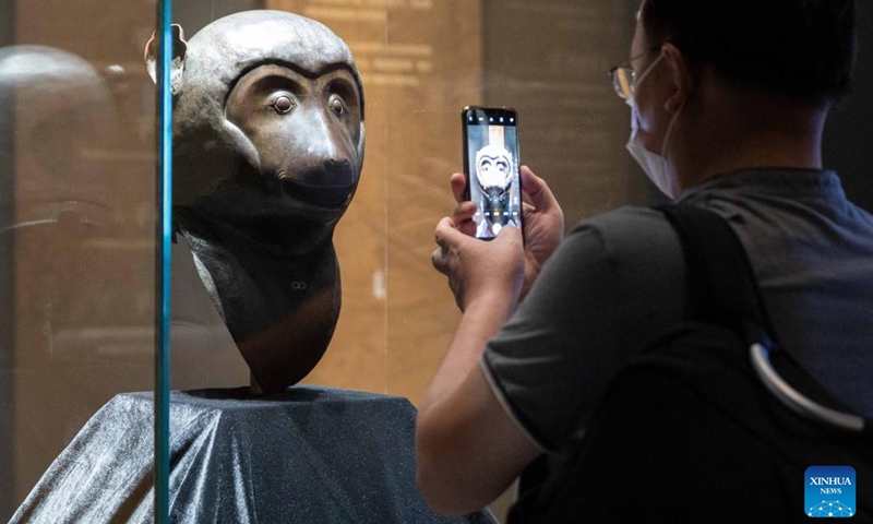 A visitor takes photos of a bronze monkey head at the exhibition Return in Golden Age: China's Retrieved Cultural Relics Exhibition in east China's Shanghai, Sept. 26, 2022. Return in Golden Age: China's Retrieved Cultural Relics Exhibition was launched Monday at the Minhang Museum in east China's Shanghai. The exhibition features China's cultural relics retrieved from overseas and now kept by the Poly Art Museum and the administration office of the Yuanmingyuan.(Photo: Xinhua)