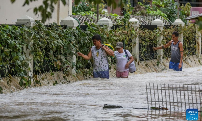 Residents wade through a flooded road in Bulacan Province, the Philippines, Sept. 26, 2022. Super typhoon Noru slammed Luzon island in the Philippines with heavy rainfall and winds since Sunday afternoon, leaving five people dead, as it blew away from the Southeast Asian country on Monday.(Photo: Xinhua)