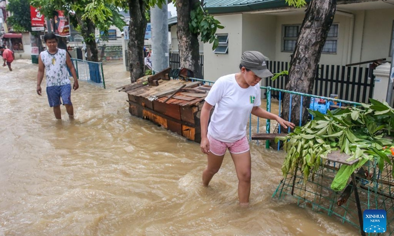 Residents wade through a flooded road in Bulacan Province, the Philippines, Sept. 26, 2022. Super typhoon Noru slammed Luzon island in the Philippines with heavy rainfall and winds since Sunday afternoon, leaving five people dead, as it blew away from the Southeast Asian country on Monday.(Photo: Xinhua)