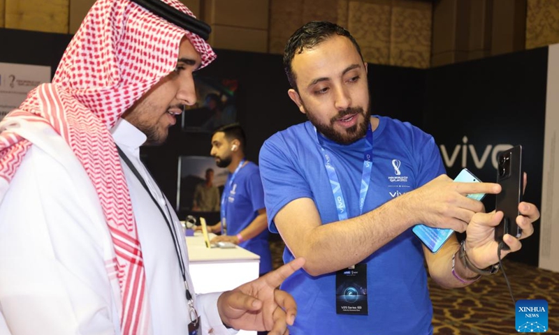 A staff member introduces a new smartphone to a visitor during a launch of Vivo's new products in Riyadh, Saudi Arabia, on Sept. 26, 2022. Chinese phone maker Vivo unveiled on Monday two 5G smartphones in Riyadh. At its launch of new products in the kingdom, Vivo presented the latest additions to its 5G smartphones V series: V25 and V25 Pro, which feature superior photography.(Photo: Xinhua)