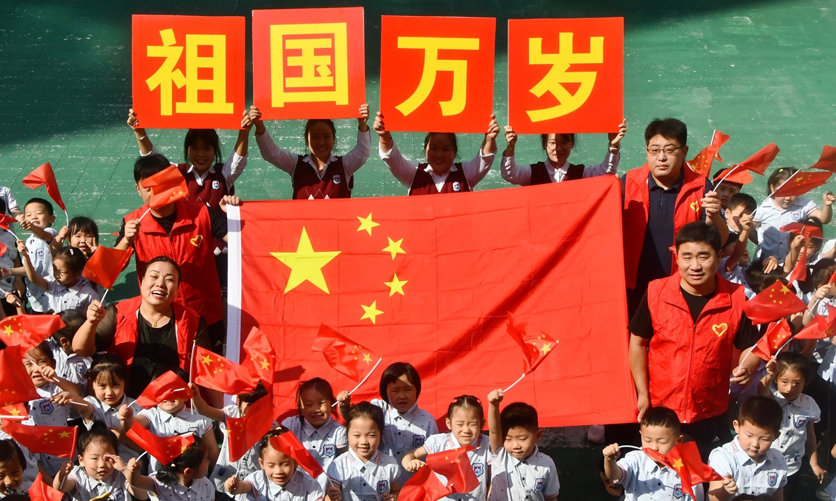 Children wave national flags with community volunteers at a kindergarten in Handan, North China's Hebei Province on September 29, 2022 ahead of the National Day holidays. Photo: IC