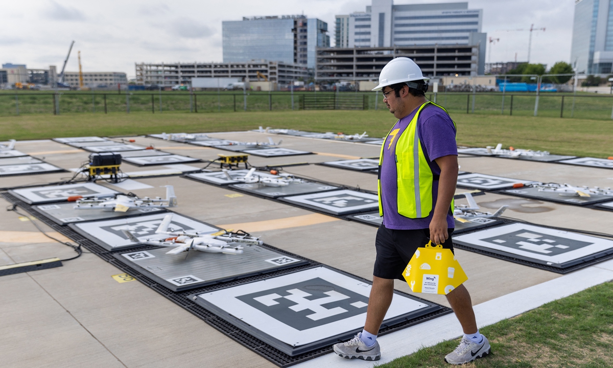 Jose Paz, a Wing ground support manager, walks to a drone while preparing a delivery during a demonstration at a Wing facility in Frisco, Texas, the US, on August 31, 2022. Photo: AFP