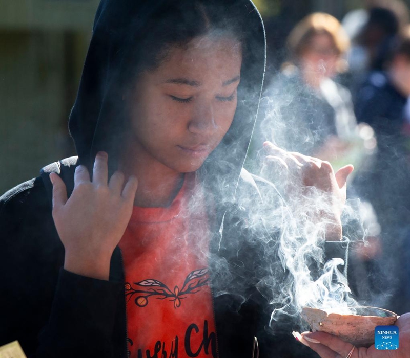 A student takes part in a smudging ceremony of a commemoration during the National Day for Truth and Reconciliation in Toronto, Canada, on Sept. 30, 2022. Canada marked its second National Day for Truth and Reconciliation on Friday to honor lost children and survivors of the notorious indigenous residential school system in the country. (Photo by Zou Zheng/Xinhua)