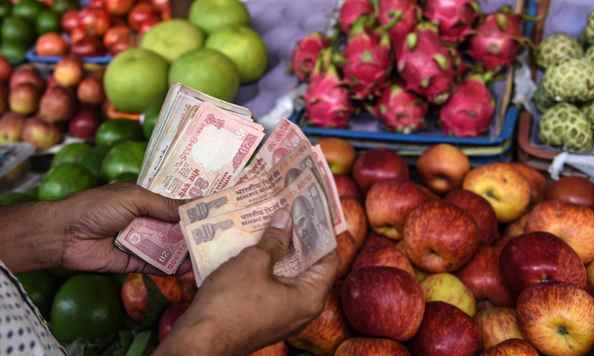 A vendor counts Indian currency notes at a vegetable market in Mumbai, India, Aug. 30, 2018. (Xinhua/Stringer) 
