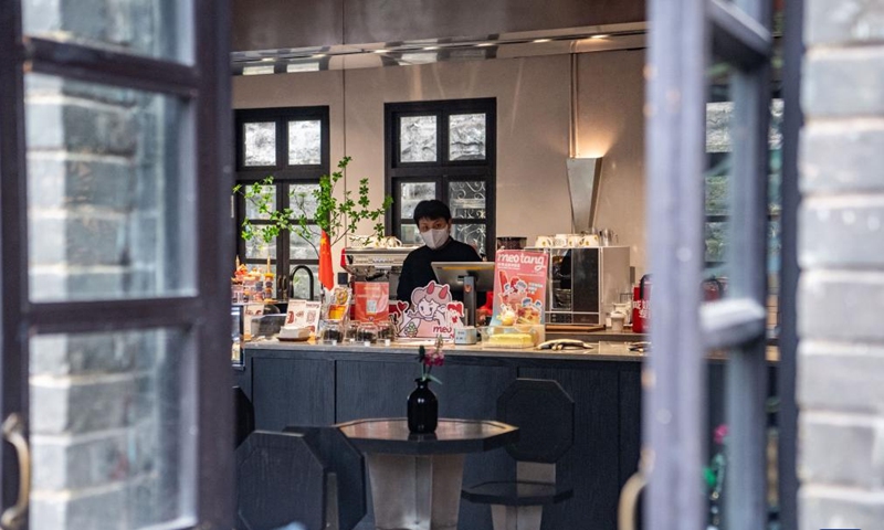 A staff member makes coffee in a commercial complex reconstructed from an old building in Yuzhong District, southwest China's Chongqing, Oct. 6, 2022.Photo:Xinhua