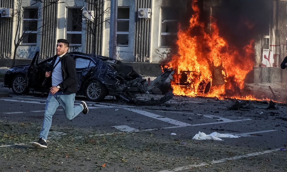 A man runs from a burning site after Russian strikes hit the Ukrainian capital Kiev on October, 10, 2022. Photo: IC