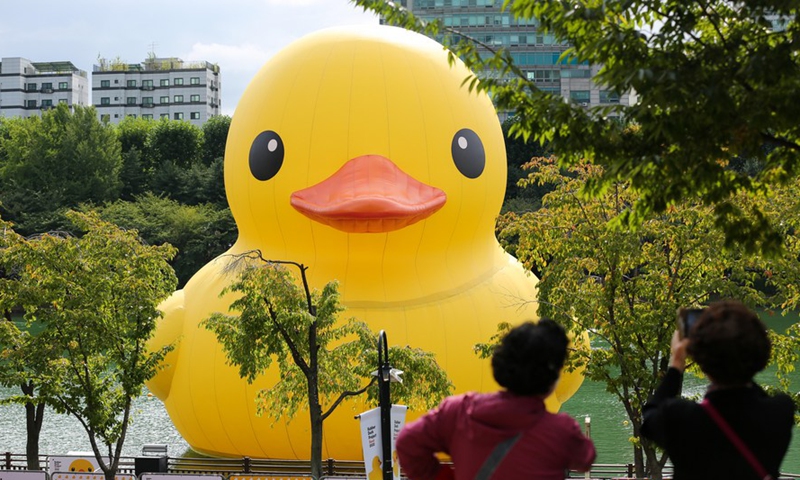 People watch and take a photo of the Rubber Duck designed by Dutch artist Florentijn Hofman on the Seokchon Lake in Seoul, South Korea, Oct. 6, 2022.Photo:Xinhua