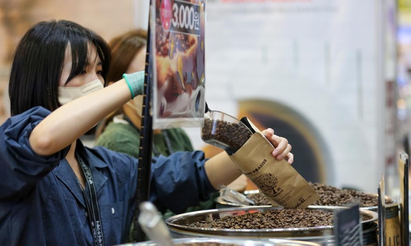 An exhibitor packs coffee beans at the Cafe and Bakery Fair in Goyang, South Korea, Oct. 7, 2022. The fair will last till Oct. 9.Photo:Xinhua