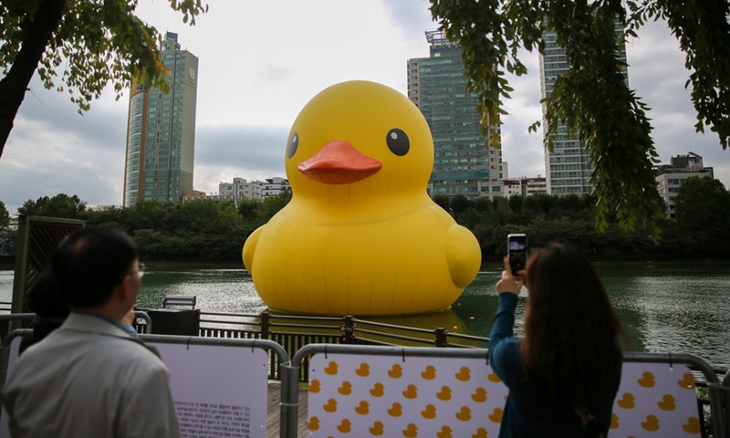 People watch and take a photo of the Rubber Duck designed by Dutch artist Florentijn Hofman on the Seokchon Lake in Seoul, South Korea, Oct. 6, 2022.Photo:Xinhua
