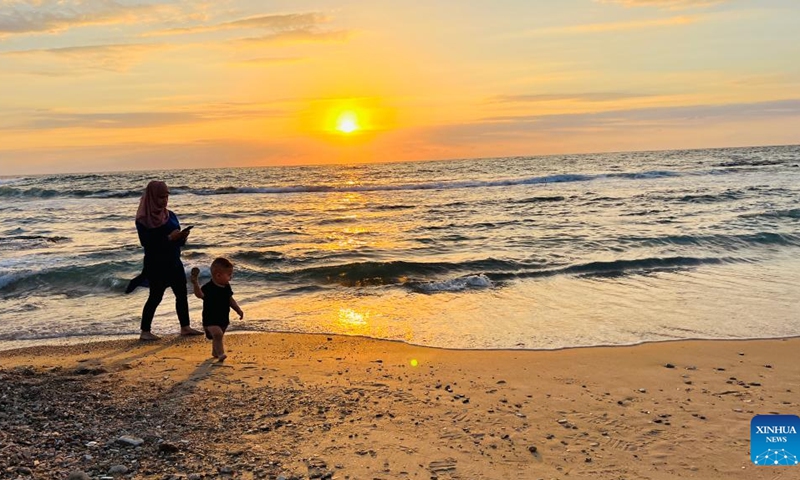 People enjoy the sunset over the Mediterranean Sea in Tel Aviv, Israel, on Oct. 7, 2022.(Photo: Xinhua)