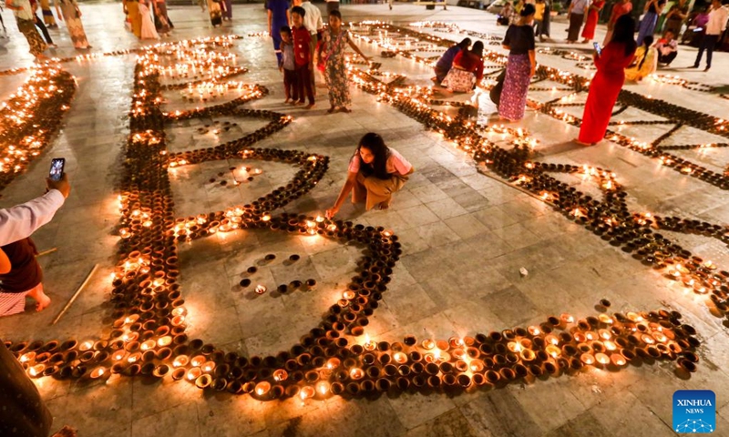 People light candles on the full moon day of Thadingyut lighting festival in Yangon, Myanmar, Oct. 9, 2022.