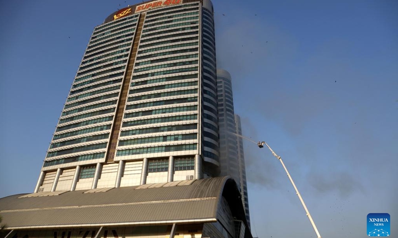 A firefighter tries to extinguish a fire on a prime building in Islamabad, capital of Pakistan, Oct. 9, 2022. A fire erupted in the Pakistani capital Islamabad's Centaurus, a prime building consisting of a major shopping mall and elite residential apartments, on Sunday afternoon, officials and police sources said. The sources said that no casualty has been reported in the fire, and people in the building are being helped to get evacuated from the mall.(Photo: Xinhua)