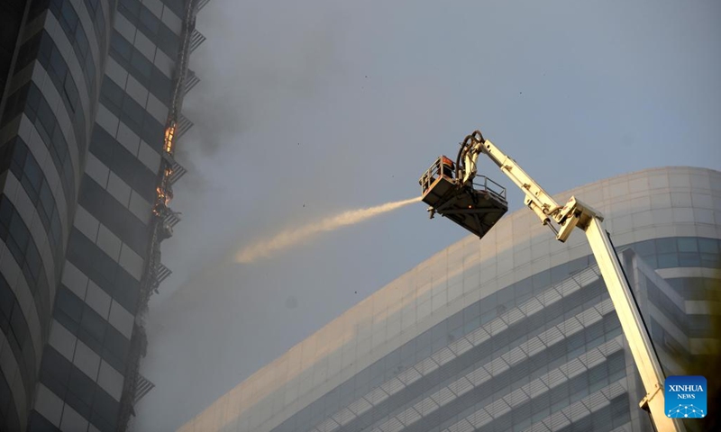A firefighter tries to extinguish a fire on a prime building in Islamabad, capital of Pakistan, Oct. 9, 2022. A fire erupted in the Pakistani capital Islamabad's Centaurus, a prime building consisting of a major shopping mall and elite residential apartments, on Sunday afternoon, officials and police sources said. The sources said that no casualty has been reported in the fire, and people in the building are being helped to get evacuated from the mall.(Photo: Xinhua)