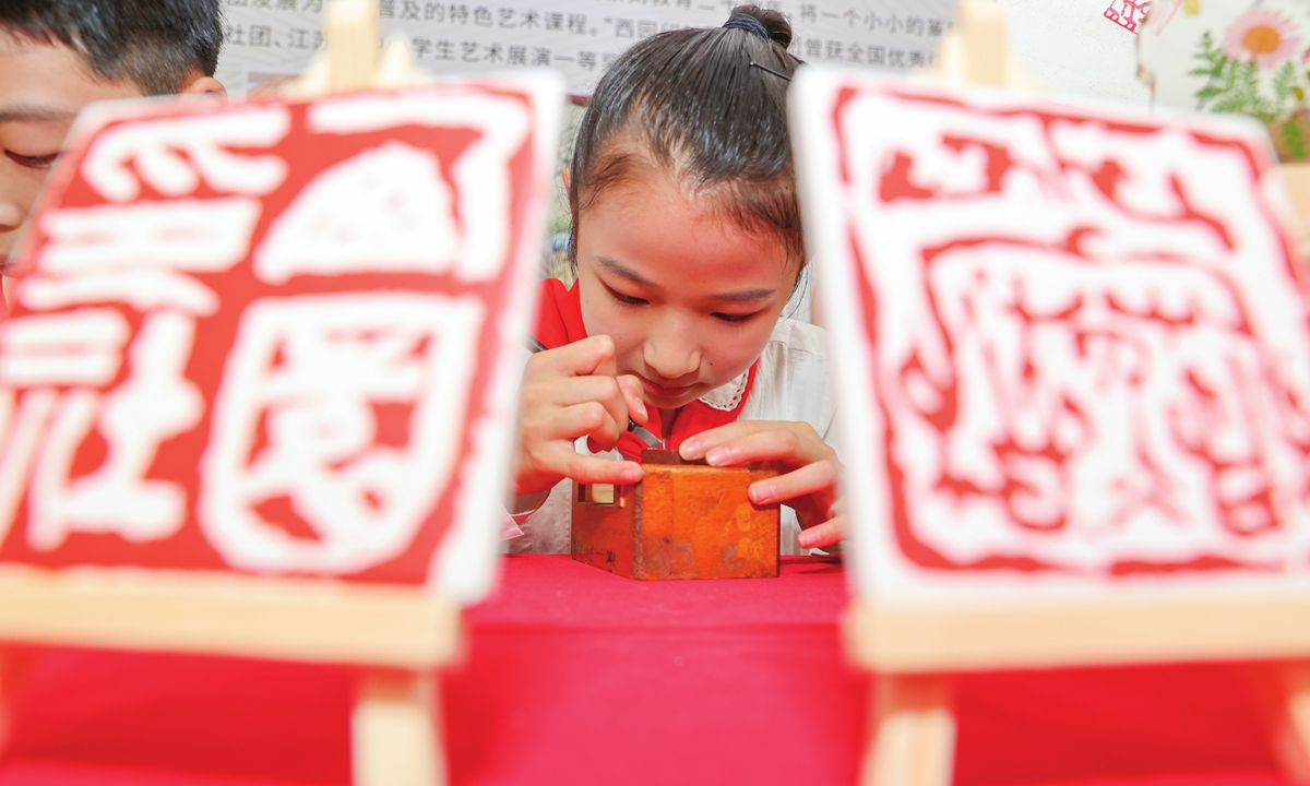A child practices Chinese seal carving in Wuxi, Jiangsu Province. Photo: IC 