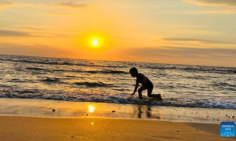 A boy enjoys the sunset over the Mediterranean Sea in Tel Aviv, Israel, on Oct. 7, 2022.(Photo: Xinhua)