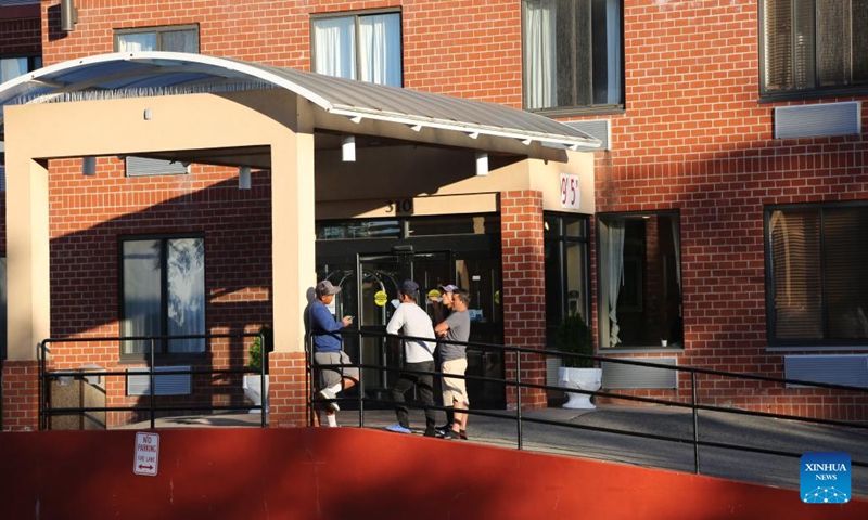 Asylum seekers are seen at the entrance of a Comfort Inn hotel in Staten Island, New York, the United States, on Oct. 9, 2022. The thousands of newly arrived asylum seekers in New York City, the most populous city in the United States, are facing multifaceted challenges in taking roots amid an ongoing humanitarian crisis.(Photo: Xinhua)