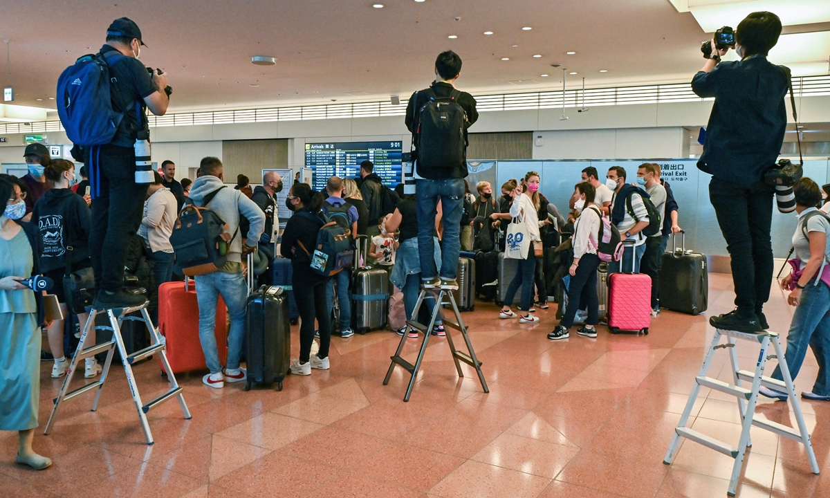 Press photographers stand on ladders to take images of a tour group after their arrival at the international terminal of Tokyo's Haneda Airport on October 11, 2022, as Japan reopened to foreign travelers after two and a half years of COVID-19 restrictions. Photo: AFP