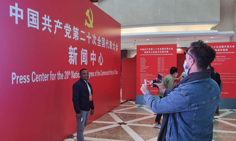 A journalist poses for a photo at the press center for the 20th National Congress of the Communist Party of China (CPC) in Beijing, capital of China, on Oct 12, 2022. The press center for the upcoming 20th National Congress of the Communist Party of China (CPC) officially opened on Wednesday to provide services for journalists covering the congress. (Photo:Xinhua)