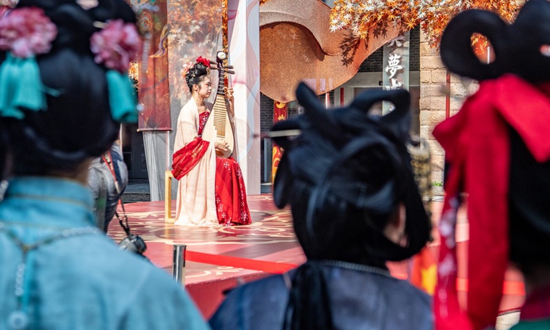 A woman wearing Hanfu, a type of traditional Chinese style garment, performs in Ciqikou ancient town, southwest China's Chongqing Municipality, Oct. 2, 2022(Photo: Xinhua)
