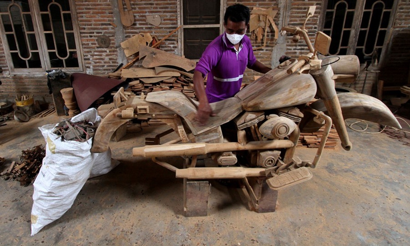 A worker makes a wooden craft motorbike at Tetap Jaya Art wooden workshop in Boyolali, Central Java, Indonesia. Oct. 11, 2022.(Photo: Xinhua)