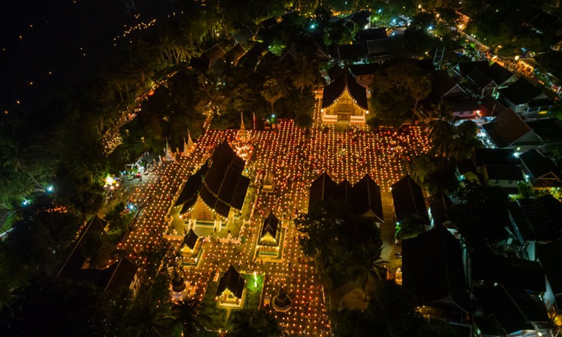 Drone photo shows people lighted lanterns in the ancient town of Luang Prabang, a world heritage site, to float on Mekong River on Oct. 11, 2022. (Photo: Xinhua)