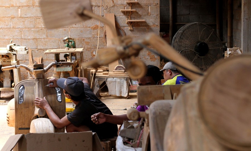 A worker makes a wooden craft motorbike at Tetap Jaya Art wooden workshop in Boyolali, Central Java, Indonesia. Oct. 11, 2022.(Photo: Xinhua)