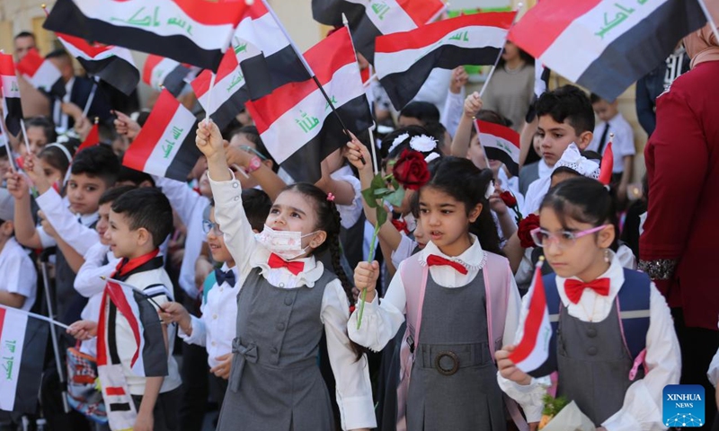 Students wave national flags on the first day of the new school year in Baghdad, Iraq, Oct. 12, 2022.(Photo: Xinhua)