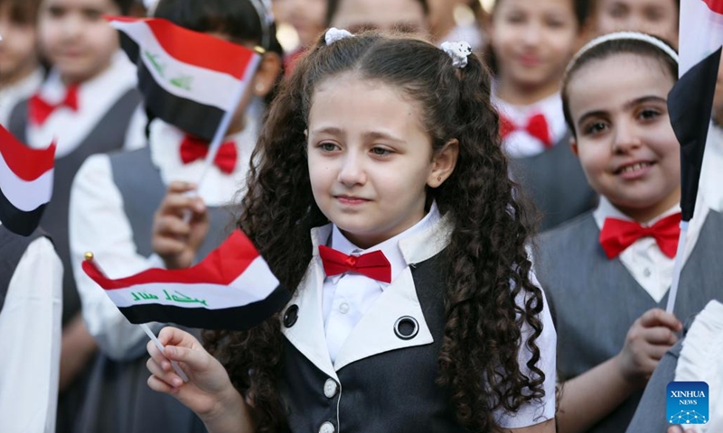 Students wave national flags on the first day of the new school year in Baghdad, Iraq, Oct. 12, 2022.(Photo: Xinhua)