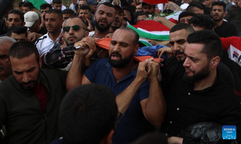 Mourners carry the body of Osama Adawi, who was killed by an Israeli soldier, during his funeral in the West Bank city of Hebron, Oct. 13, 2022. A Palestinian was killed and three others injured on Wednesday during clashes with the Israeli soldiers in Al-Aroub refugee camp north of the southern West Bank city of Hebron, Palestinian health authorities and eyewitnesses said.(Photo: Xinhua)