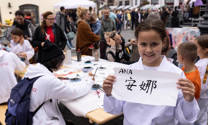 A girl shows her name in Chinese calligraphy at a charity event in Ljubljana, Slovenia, Oct. 15, 2022.Photo:Xinhua