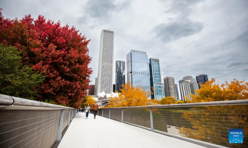 People walk along the Nichols Bridge at Millennium Park in downtown Chicago, the United States, Oct. 16, 2022. (Photo by Vincent D. Johnson/Xinhua)