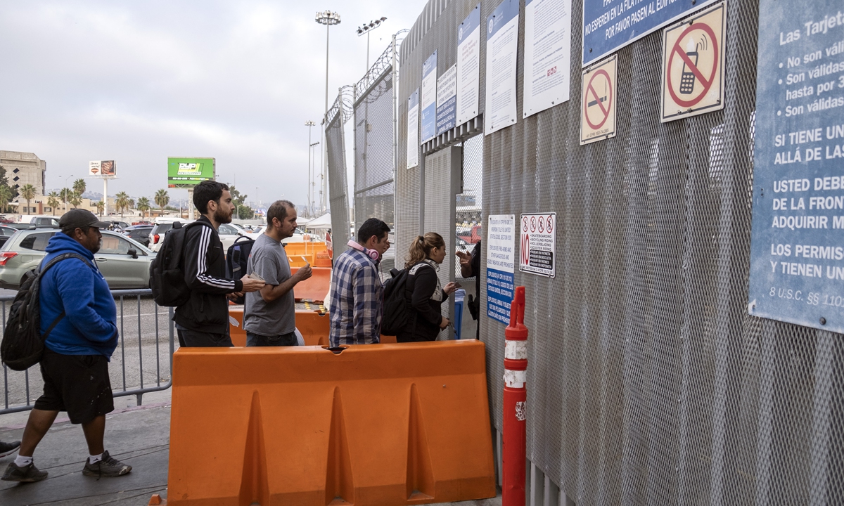 Gabriel Zarate (second from left), a US teacher who lives in Tijuana but works in San Diego in the US, heads to his home country through the San Ysidro crossing port in Tijuana, Baja California State, Mexico, on October 4, 2022. Photo: AFP