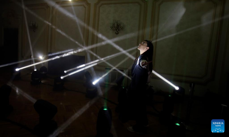A woman enjoys an interactive light installation while visiting the 3rd edition of the new media art festival RADAR in Bucharest, capital of Romania, Oct. 16, 2022. (Photo by Cristian Cristel/Xinhua)