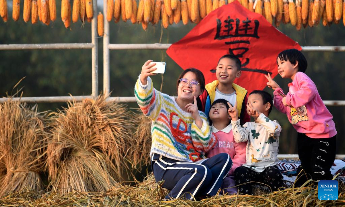 People pose for a photo at a paddy scenic spot in Huangfu Village, Chang'an District of Xi'an City, northwest China's Shaanxi Province, Oct 21, 2022. In recent years, Chang'an District develops ecological paddy fields and combines paddy rice industry with tourism, which improves the quality of local paddy rice and local economy. Photo:Xinhua