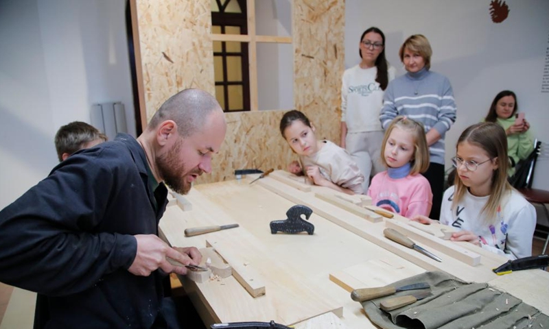 People take part in a toy-making workshop at a wooden toys exhibition in Moscow, Russia, Oct. 15, 2022.Photo:Xinhua