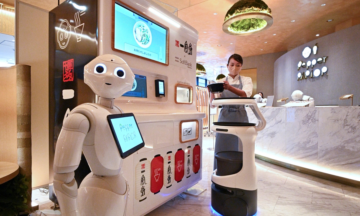A serving robot prepares to deliver a bowl of noodles made by another machine to a customer at a demonstration by Japan's SoftBank Robotics aimed to help restaurants provide completely unmanned services in Tokyo, Japan, on October 18, 2022. Photo: AFP
