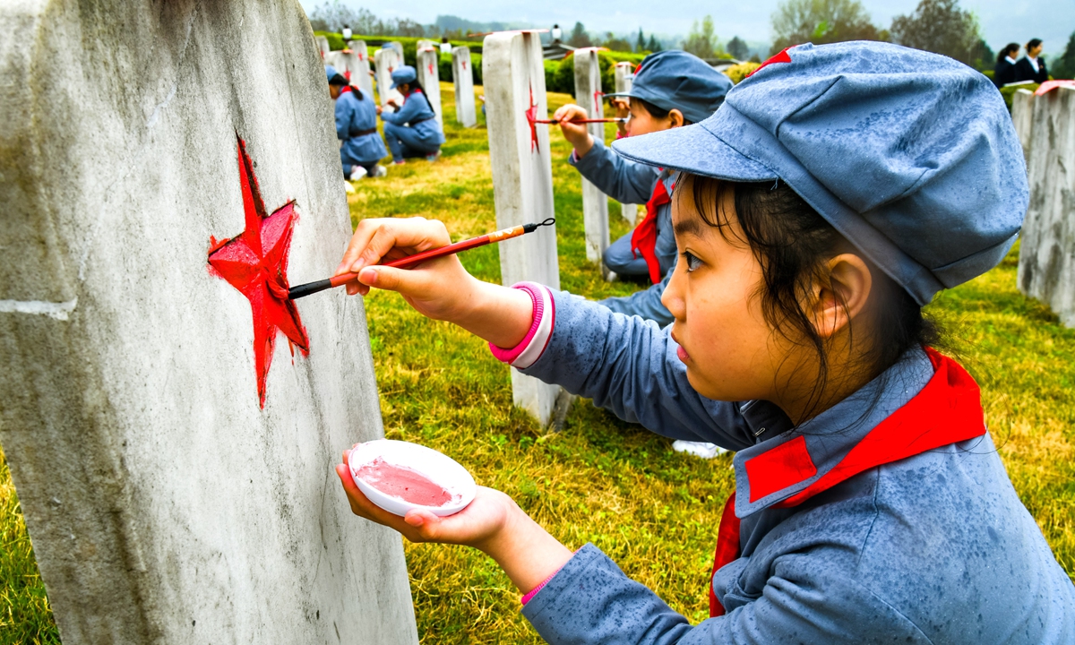 Children in Tongjiang county, Sichuan paint pentastars on the tombstones of revolutionary martyrs on March 30, 2022.Photo:IC