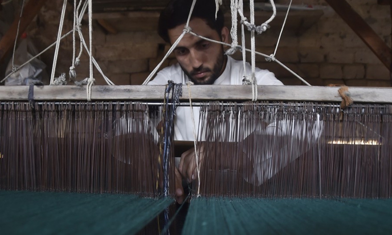 A worker works at a traditional shawl factory on the outskirts of northwest Charsadda, Pakistan, on Oct. 17, 2022.(Photo: Xinhua)